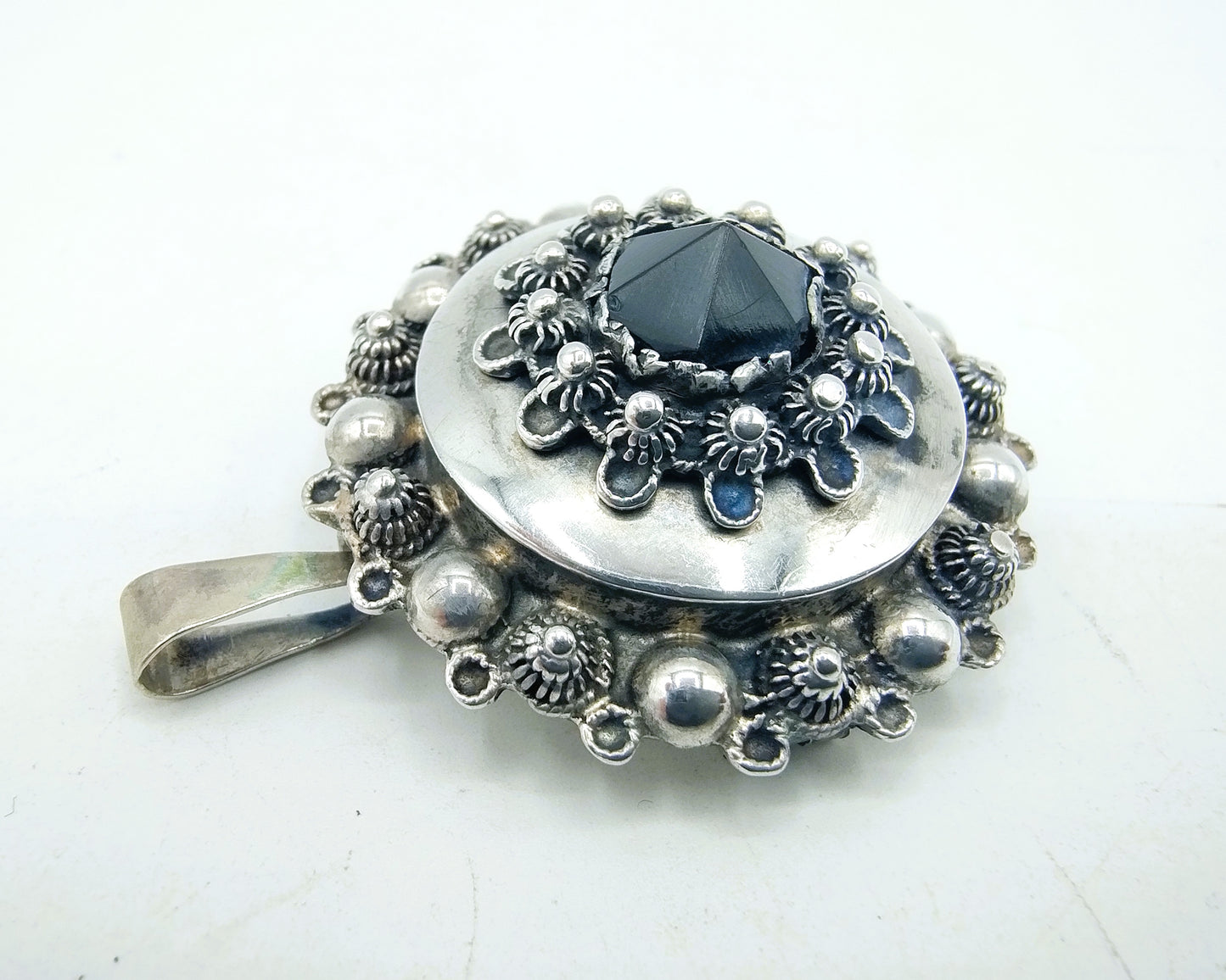 Silver brooch or pendant set with Zeeland buttons and a jet.