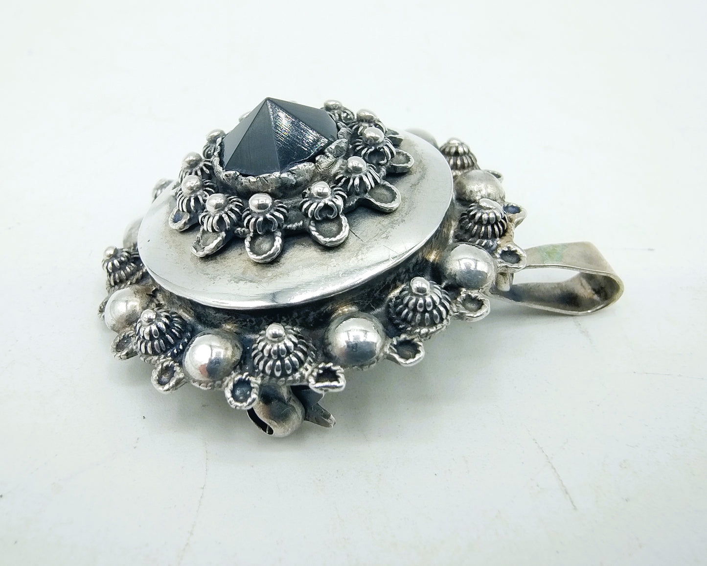 Silver brooch or pendant set with Zeeland buttons and a jet.