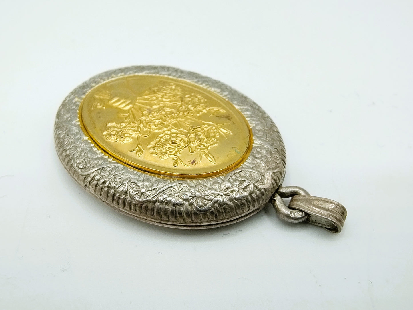 Silver medallion with flowers.