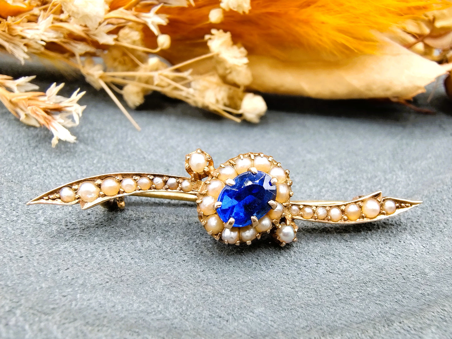 Gold brooch set with sapphire and saltwater pearls.