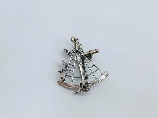 Zilveren hanger van een sextant.