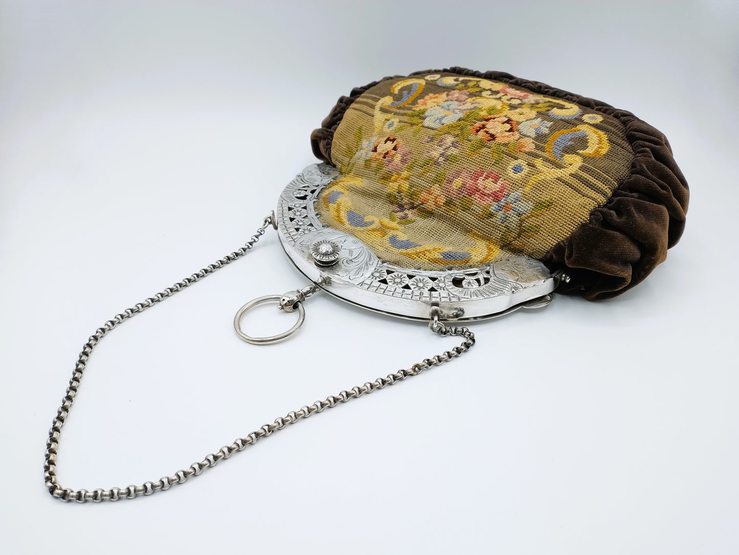 Petit Point bag with silver handle.