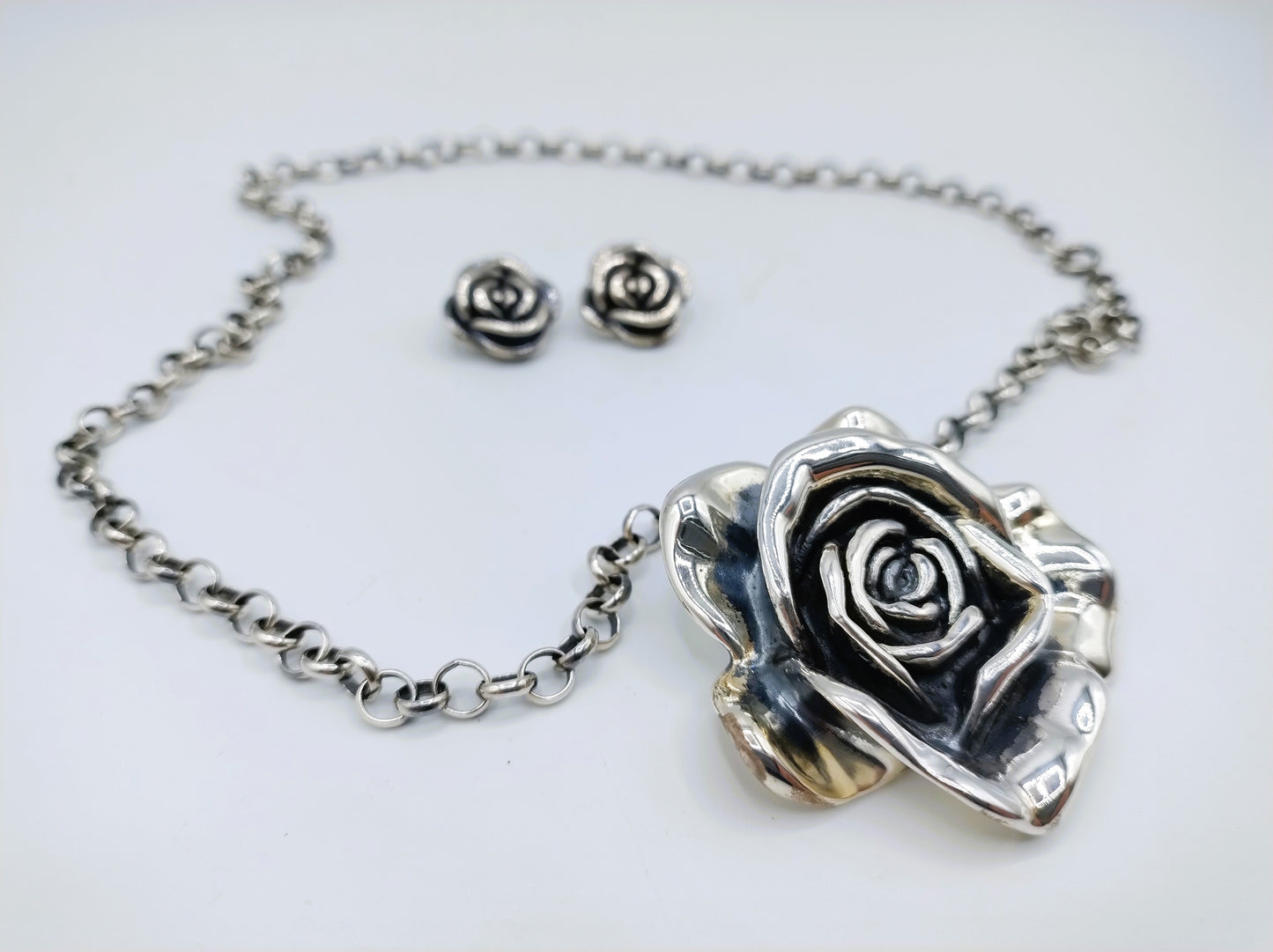 Jasseron-Kette mit silbernem Rosenanhänger und Ohrringen.