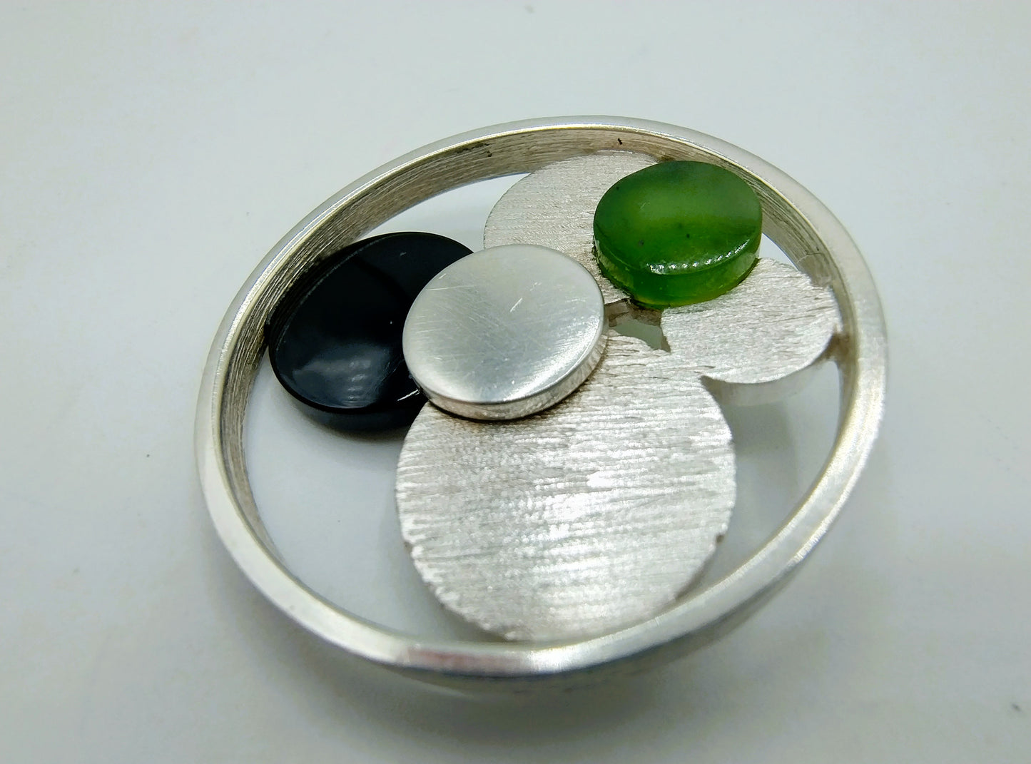Zilveren design broche met git en jade