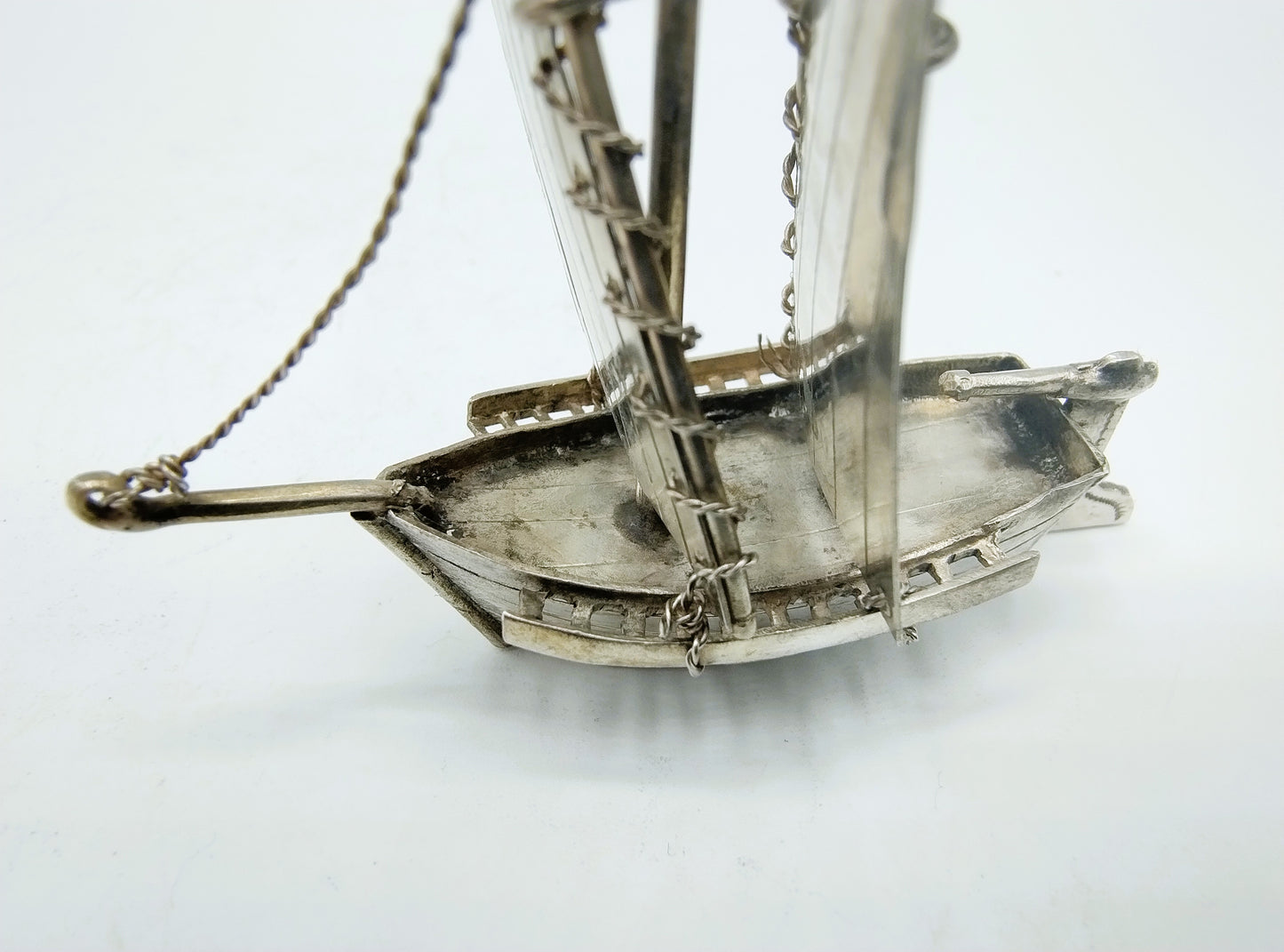 Zilveren miniatuurzeilschip detail van boeg en takelketting, close-up