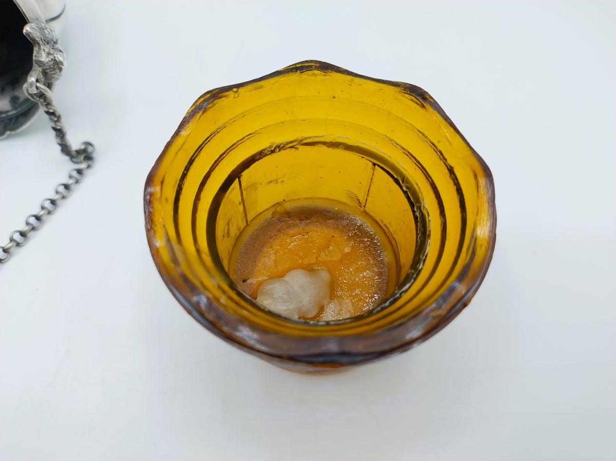 Amberkleurige glazen bak met glanzende binnenbodem en lichte vlekken.