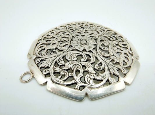 Silver pendant with curl and flower decoration