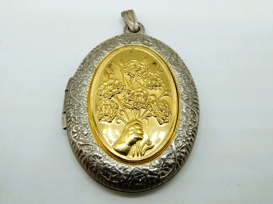 Silver medallion with flowers.