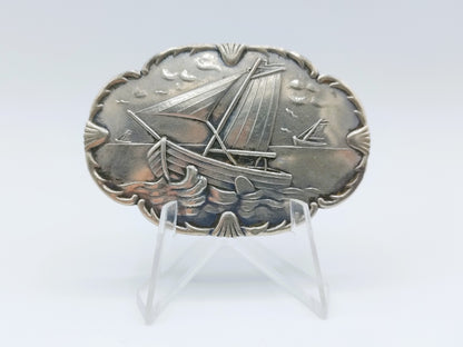 Silver brooch with botters