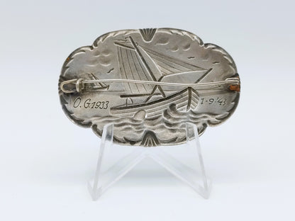 Silver brooch with botters