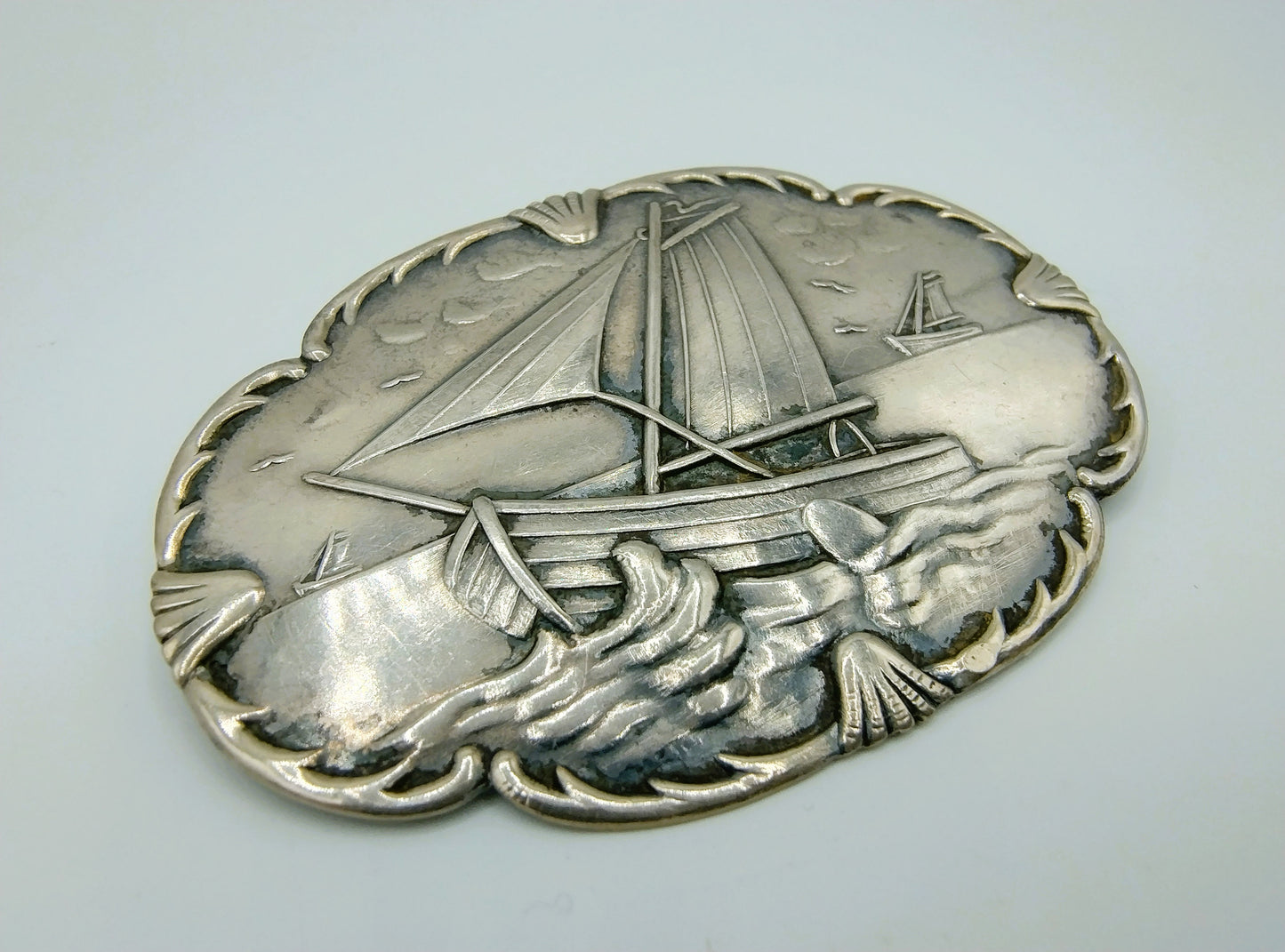 Silver brooch with botters