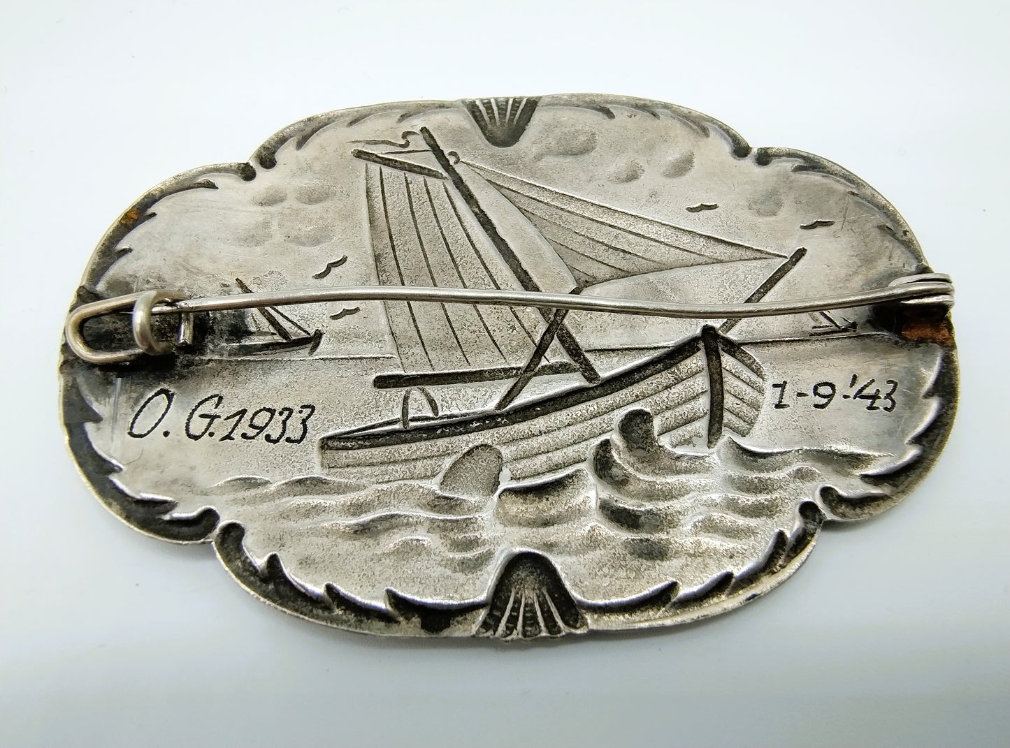 Silver brooch with botters