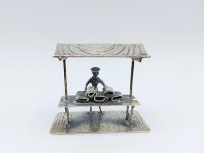 Silver miniature fabric seller