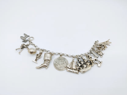 Zilveren bedelarmband met 13 bedels, o.a. penning uit 1766, 17 cm