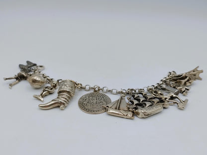 Zilveren bedelarmband met 13 bedels, o.a. penning uit 1766, 17 cm
