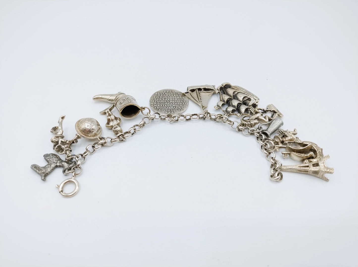 Zilveren bedelarmband met 13 bedels, o.a. penning uit 1766, 17 cm