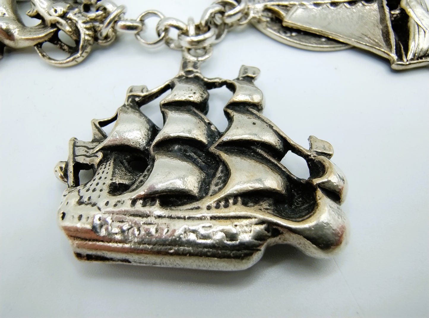 Zilveren bedelarmband met 13 bedels, o.a. penning uit 1766, 17 cm