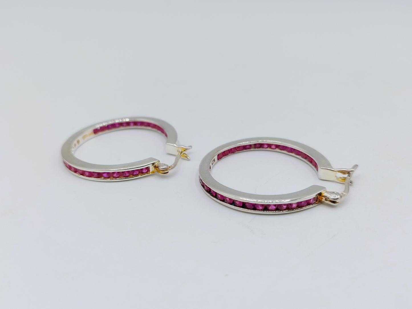 Silver hoop earrings with pink stones