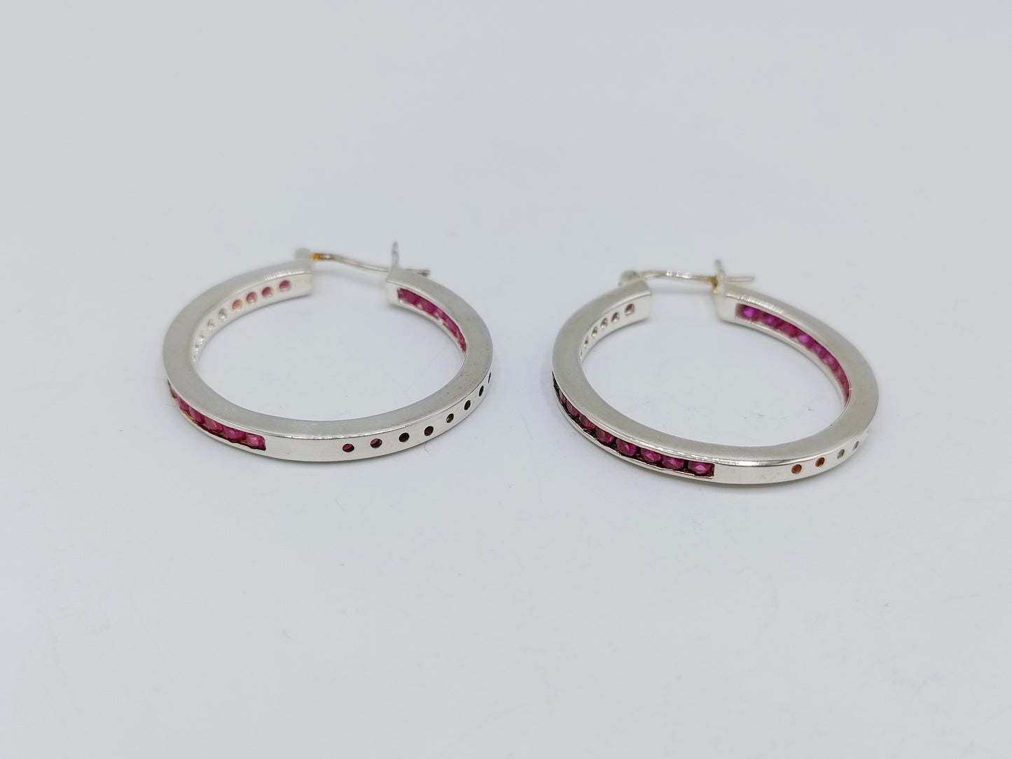 Silver hoop earrings with pink stones