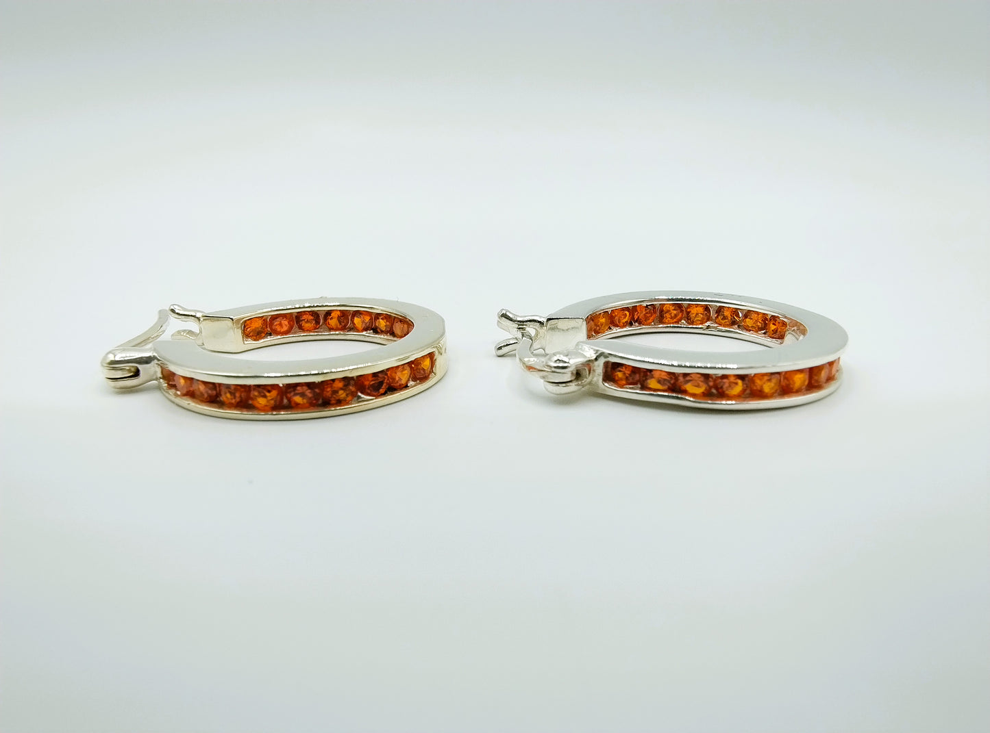 Silver hoop earrings with orange stones