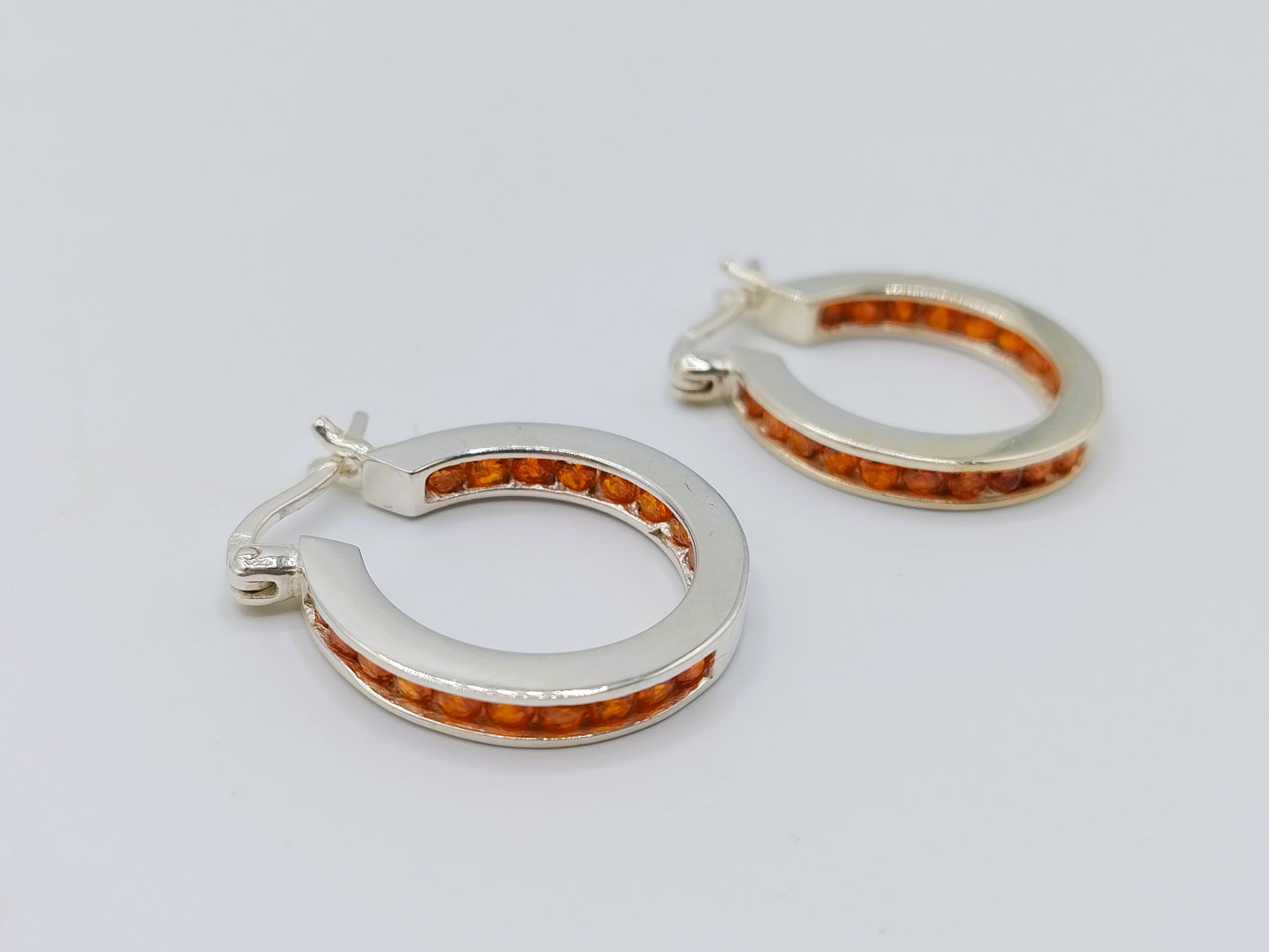 Silver hoop earrings with orange stones