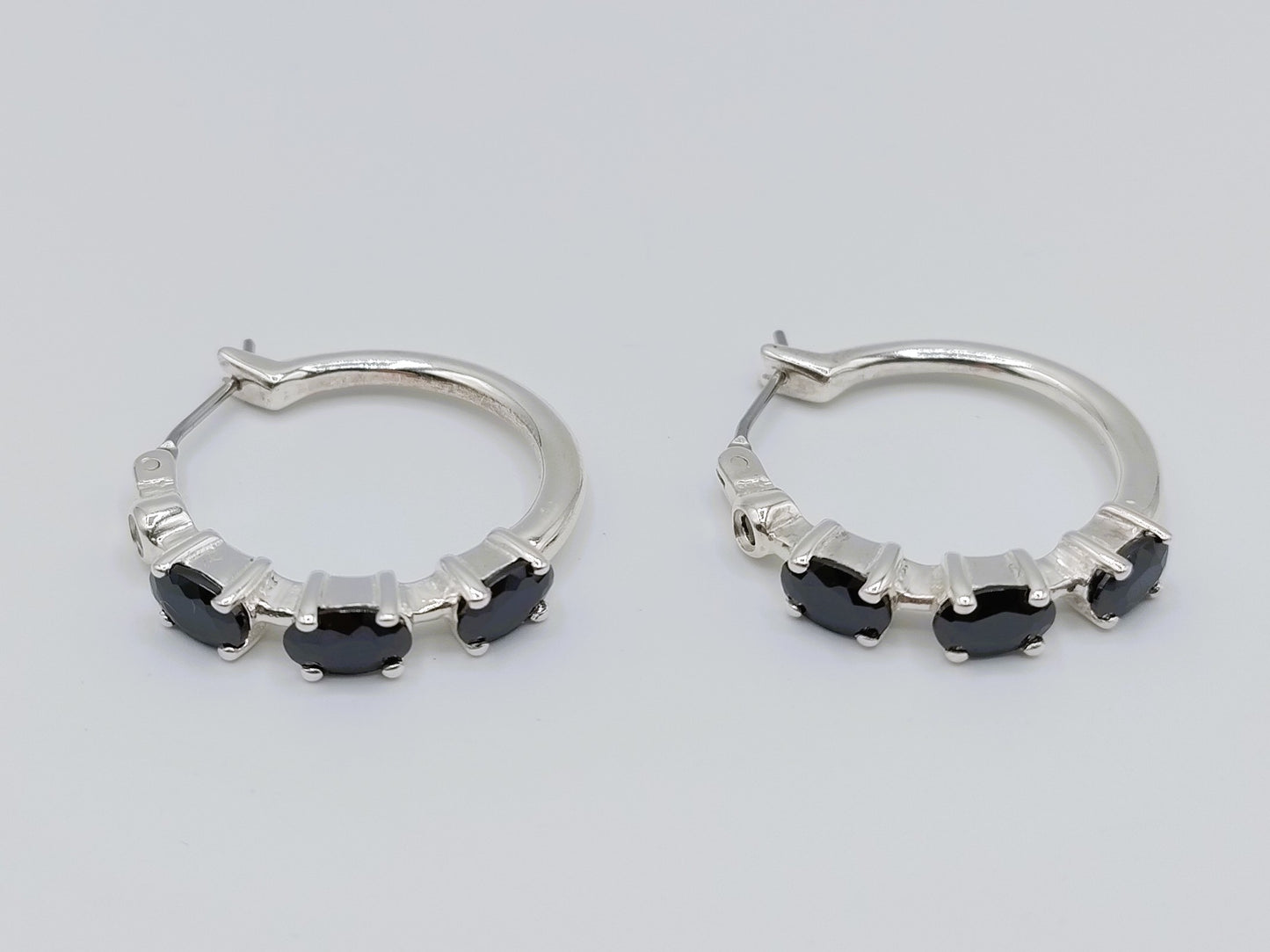 Silver hoop earrings with black stones