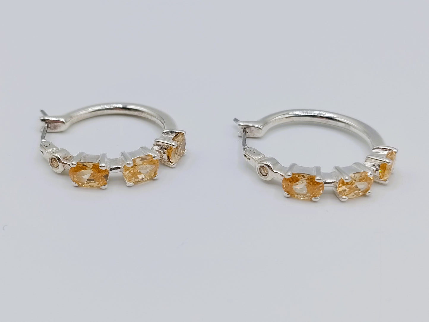 Silver hoop earrings with yellow stones