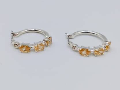 Silver hoop earrings with yellow stones