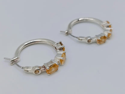 Silver hoop earrings with yellow stones