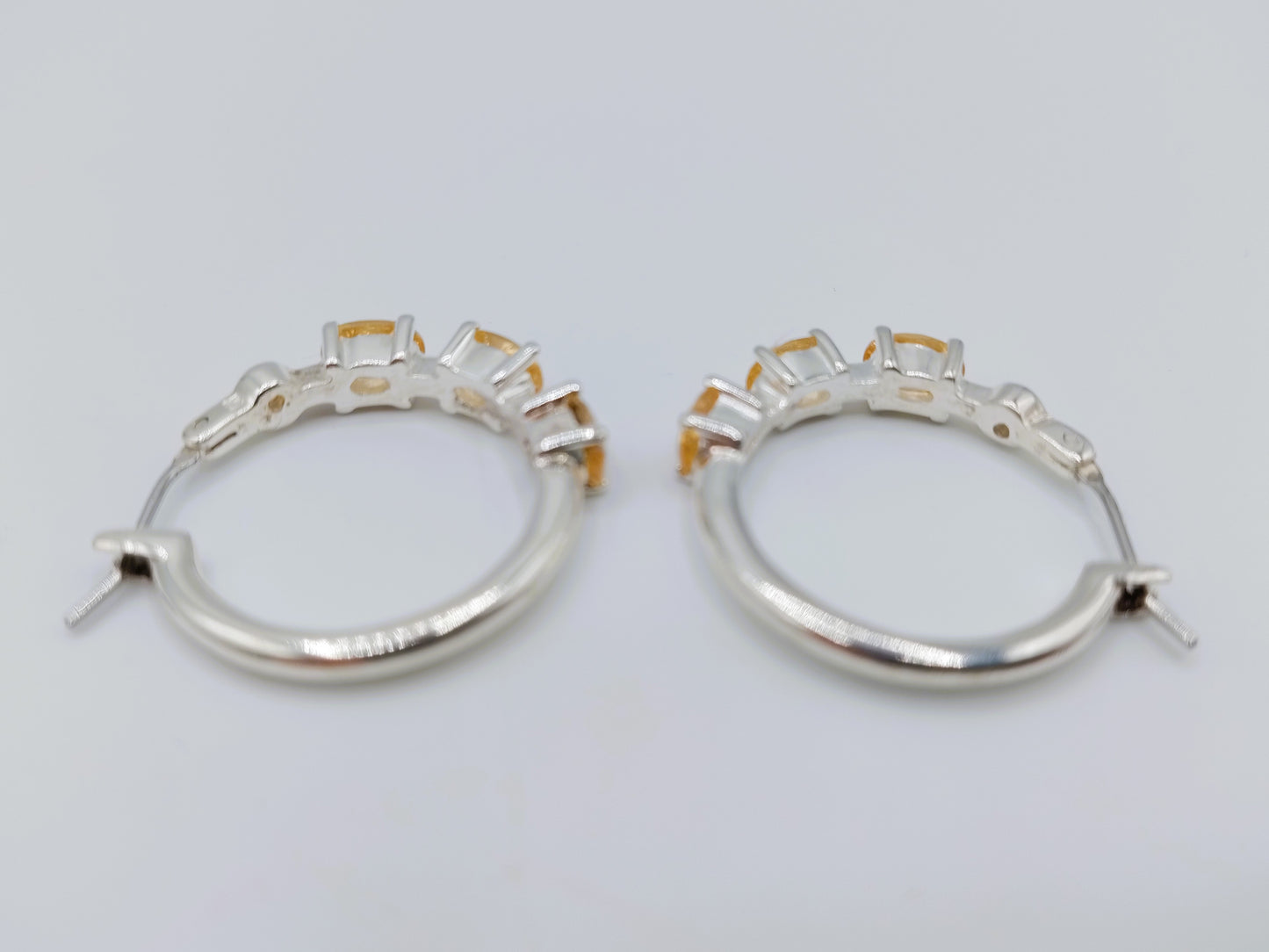 Silver hoop earrings with yellow stones
