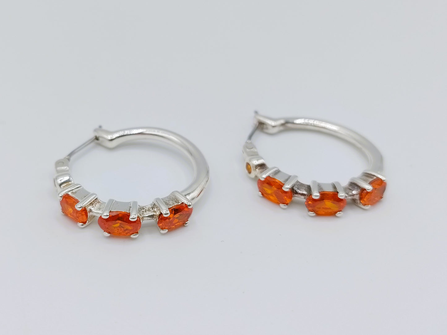 Silver hoop earrings with orange stones