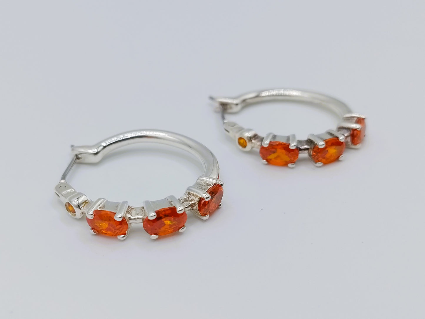 Silver hoop earrings with orange stones