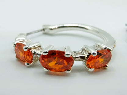 Silver hoop earrings with orange stones