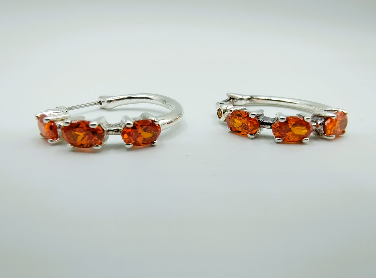 Silver hoop earrings with orange stones