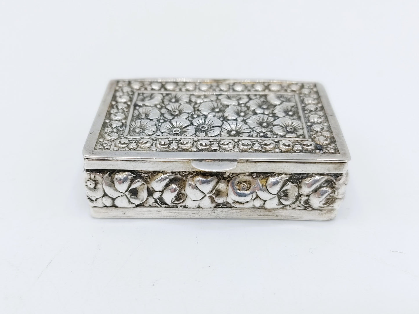 Silver pill box with a floral decoration