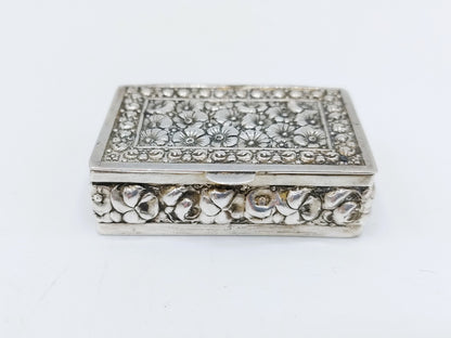 Silver pill box with a floral decoration