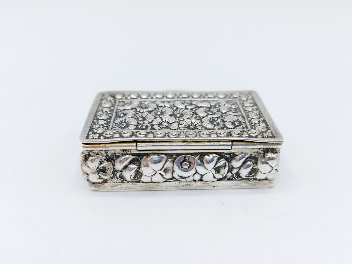 Silver pill box with a floral decoration