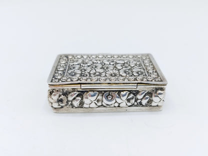 Silver pill box with a floral decoration