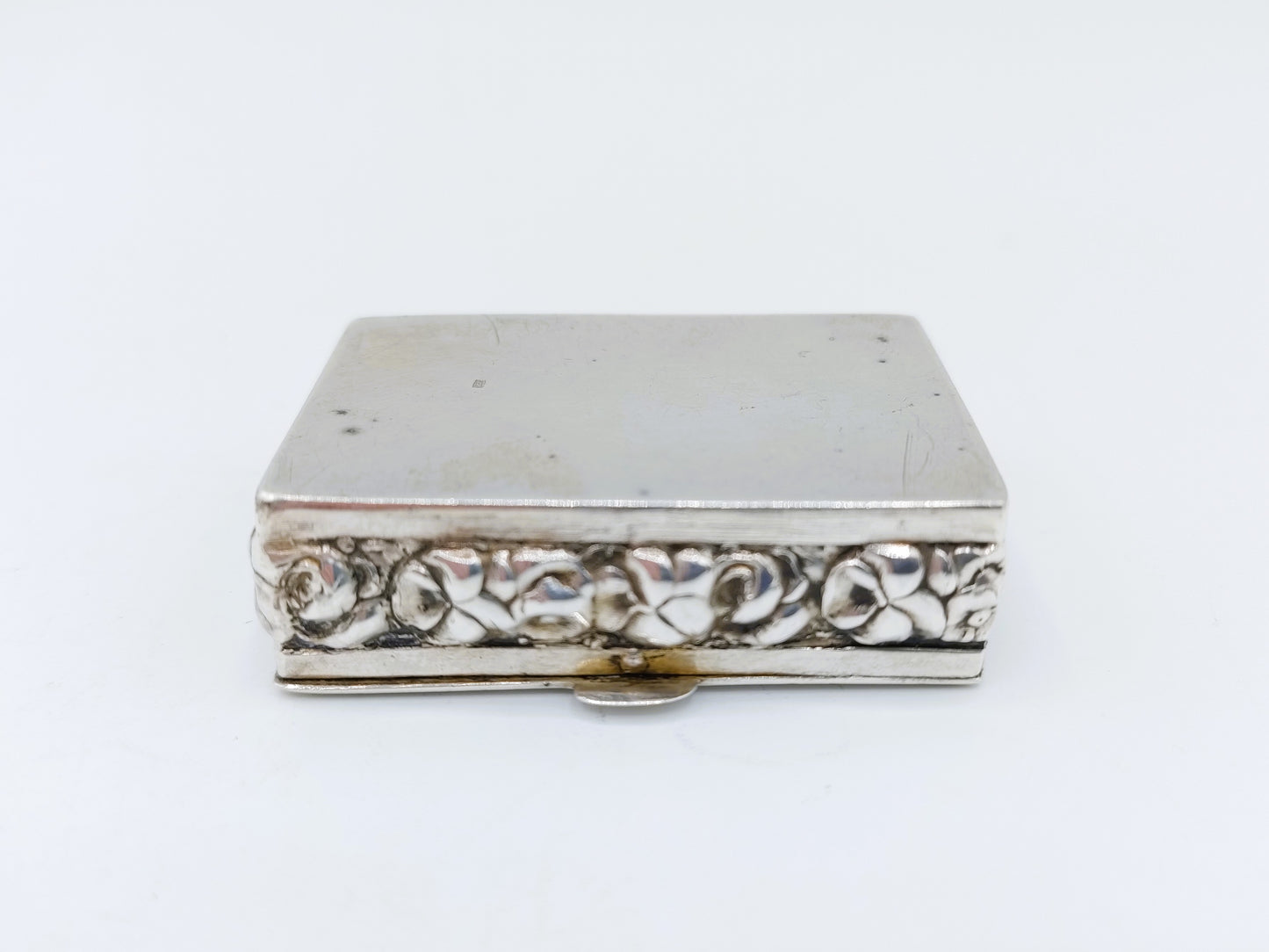 Silver pill box with a floral decoration