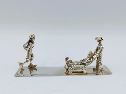 Zilveren miniatuur met slee en schaatser, 20e eeuws