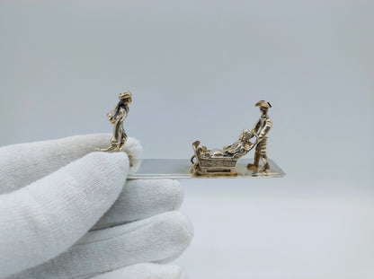 Zilveren miniatuur met slee en schaatser, 20e eeuws