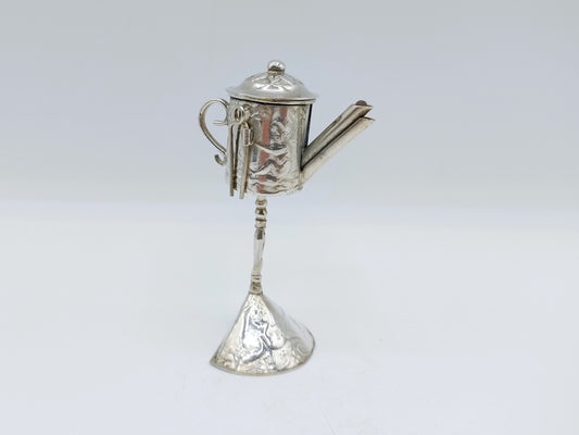 Miniatuur zilverkleurige theepot met schenktuit en lepelvormige voet