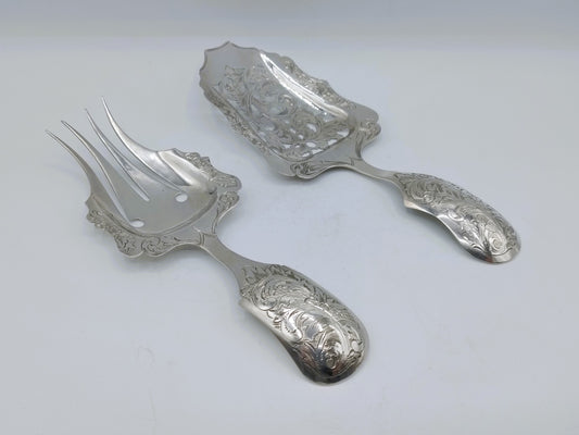 Zilveren fruitvorken en -lepel met sierlijke gravure, drie bestekstukken