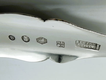 Zilveren natfruitschep met keurmerken en decor op de steel