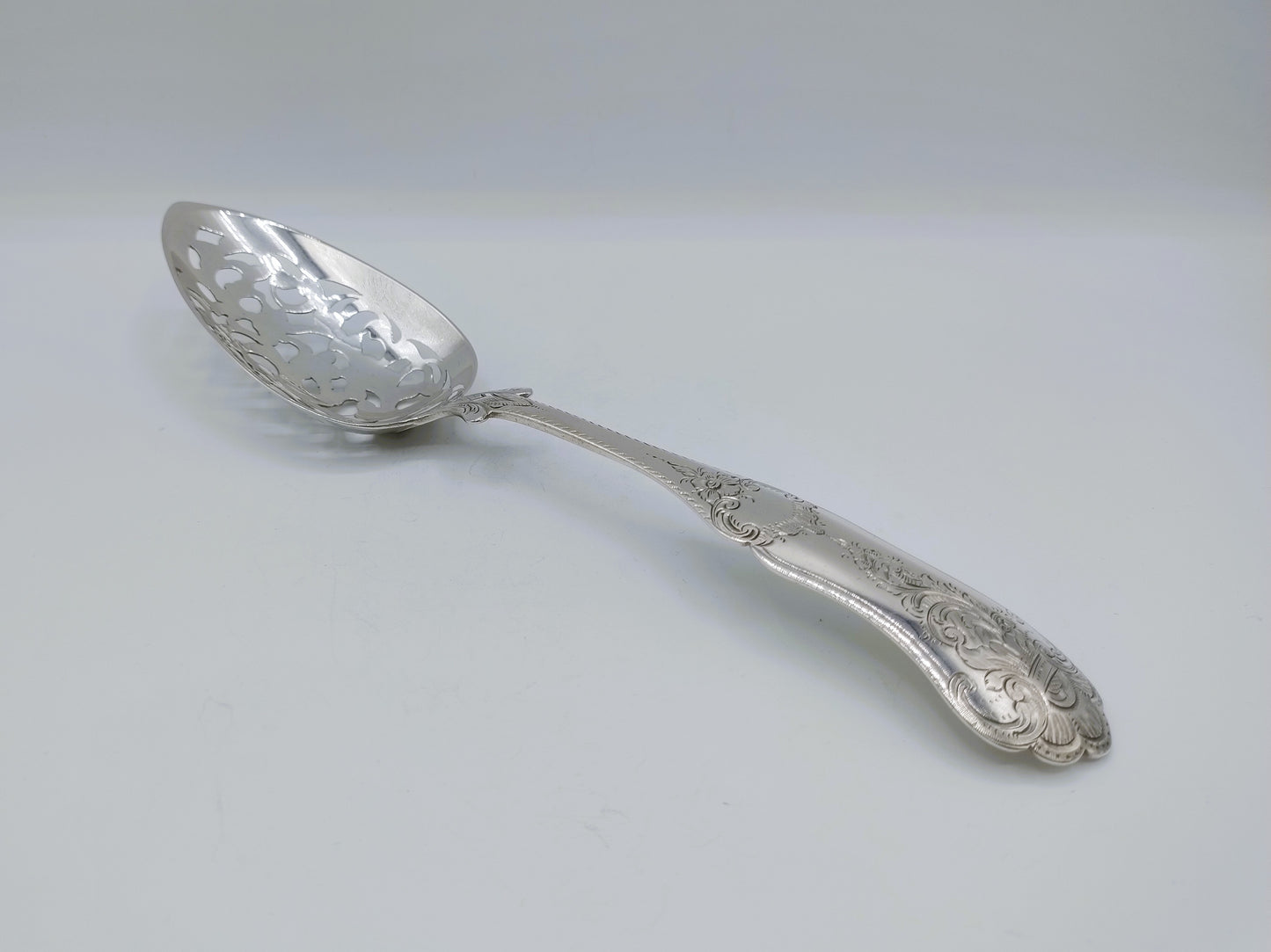 Zilveren natfruitschep met gegraveerde bolle lepel en versierde steel
