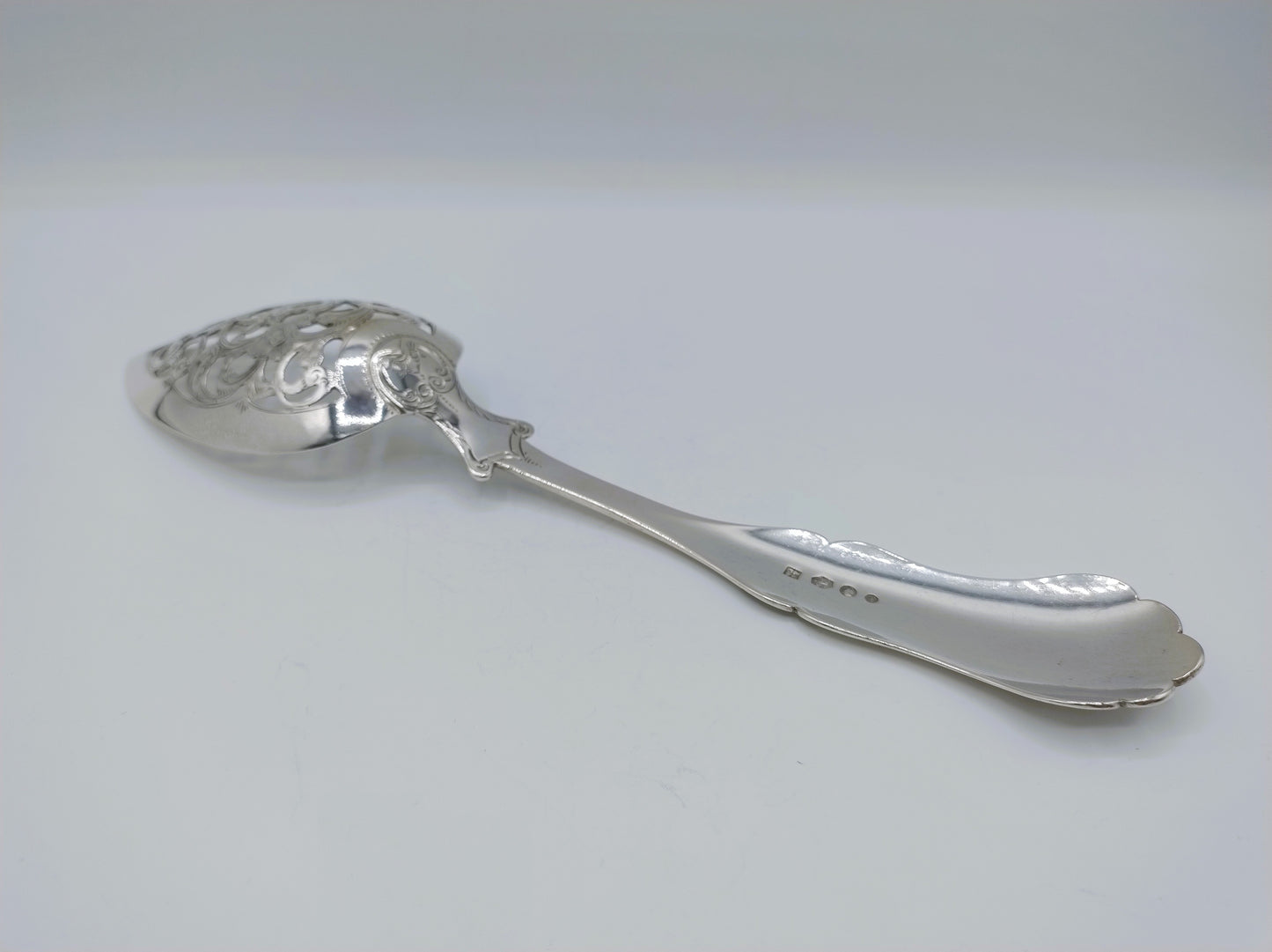 Zilveren natfruitschep met gedecoreerde steeluiteinde en ovale lepelschaal