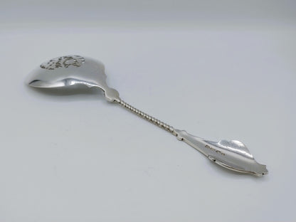 Zilveren natfruitschep met ovale kom en kettingsteel; gegraveerde details op de lepel.