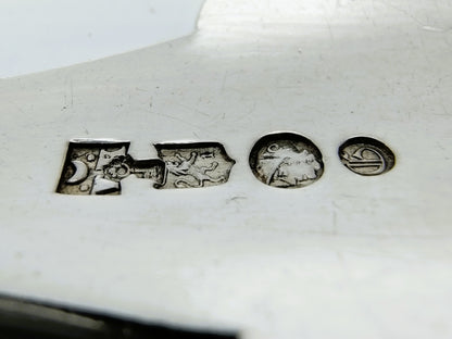 Keurmerken op zilveren lepelsteel, meerdere stempels in reliëf zichtbaar (close-up).