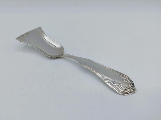 Zilveren theeschep met ovale lepel en gedetailleerde sierkrulmotief aan de steel