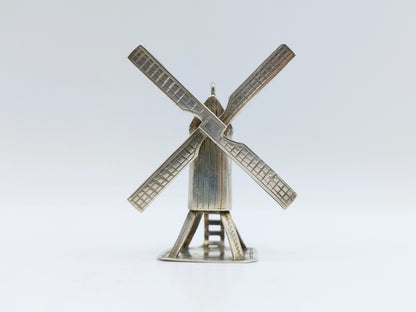 Zilveren miniatuur windmolen met vier geruite wieken en ronde voet.